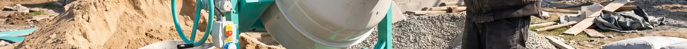 Maçon chargeant une bétonnière professionnelle à la pelle sur un chantier de maison individuelle